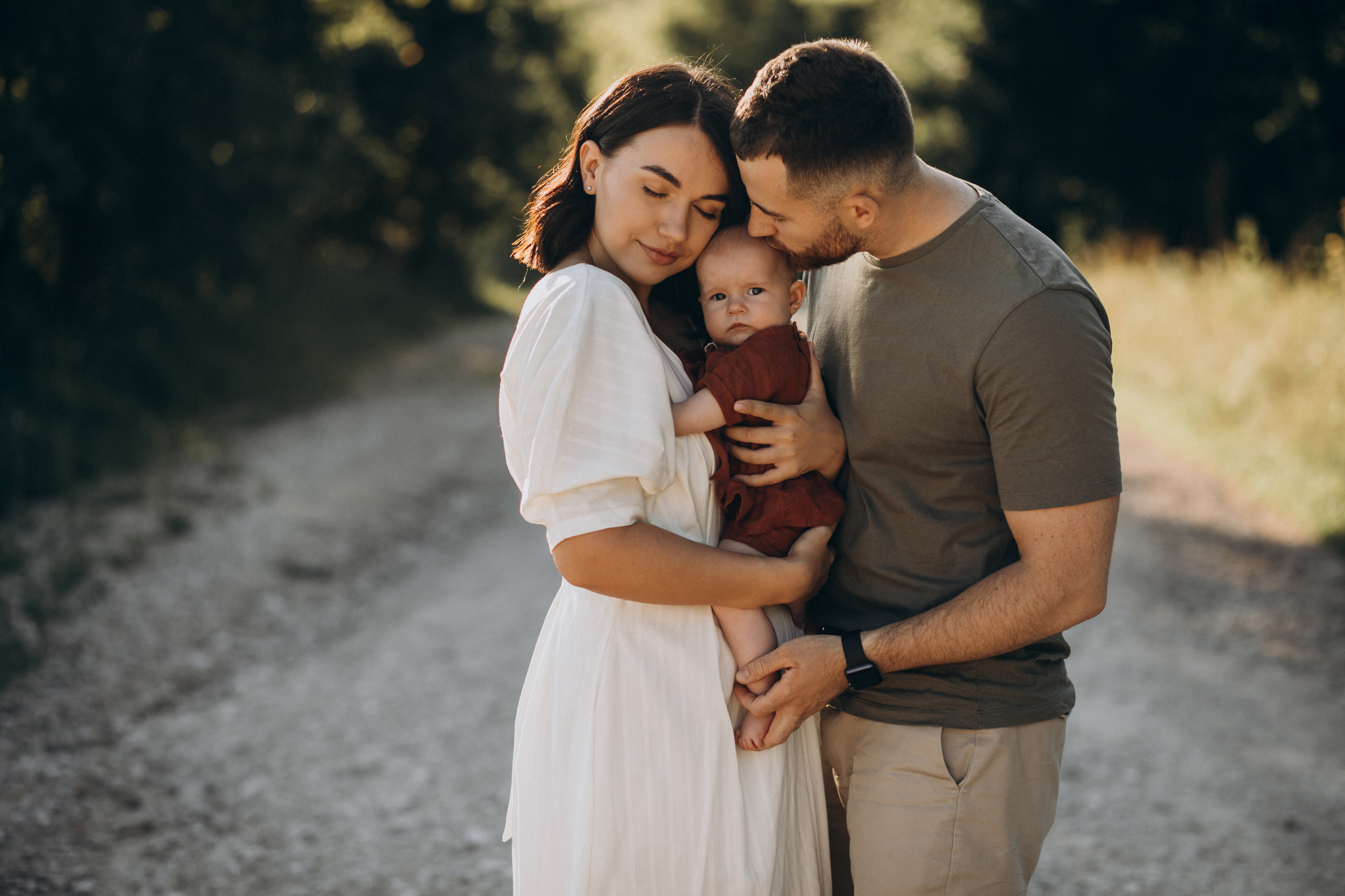 Mãe, pai e bebê abraçados